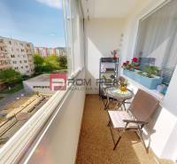 The balcony of a 3-room apartment with a view of the children's playground and residential buildings.