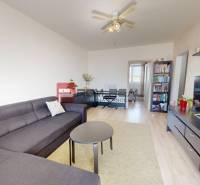 Living room in a 3-room apartment with a gray sofa, coffee table, and television.