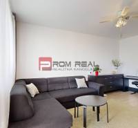 Living room in a 3-room apartment with a corner sofa, a coffee table, and a piano.