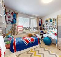 A children's room with hockey decorations, a bed, a desk, and a shelf in a 3-room apartment.