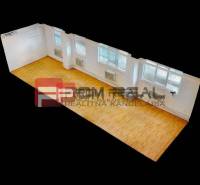 Interior of a warehouse and hall with wooden flooring and large windows.