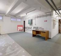 The interior of a warehouse hall with a desk and bars on the doors.