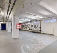 Interior of warehouses and halls with light walls, pipes, and built-in tables.