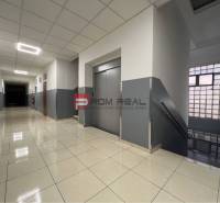 A corridor with a staircase, an elevator, and a tiled floor in warehouses and halls.