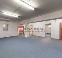 The interior of a spacious office space with multiple doors and a blue carpet in warehouses and halls.