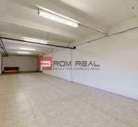 Interior of a warehouse and hall with simple lighting and white walls.