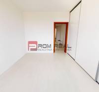 Empty room in a 4-room apartment with white walls and sliding doors.
