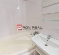 A bathroom with a corner bathtub and a sink in a 4-room apartment.
