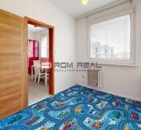 A children's room in a 4-room apartment with a blue carpet and a view from the window.