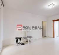 A bright room with white walls, sliding wooden doors, and two chairs in a 4-room apartment.