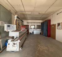 Manufacturing premises with a large machine and pipes on the ceiling.