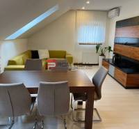 Dining table and sofa in the production area with flowers and furniture.