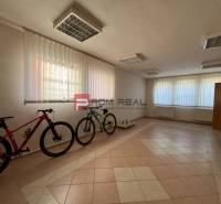 Interior of production facilities with bicycles, tiles, and windows with blinds.