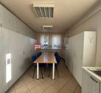 Interior of a production space with a long table and cabinets, simple equipment.