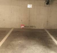A parking space in garages with a pipe on the wall.
