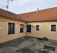 The yard of a family house on Slnečná Street in Pezinok with concrete paving and an orange facade.