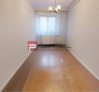 A narrow room with a wooden floor and a centrally located window under a chandelier. Family house.