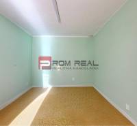 A room in a family house with green walls and a brown carpet.