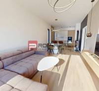 Living room in a three-room apartment with a sofa and a kitchenette.