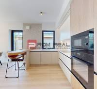 A kitchen in a 3-room apartment with a dining table and modern appliances.