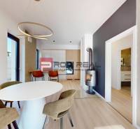 A dining room in a 3-room apartment with an oval table and a fireplace in the corner of the room.