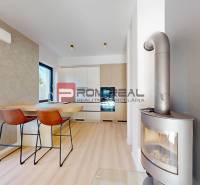 Interior of a 3-room apartment with a kitchen, bar stools, and a modern fireplace.