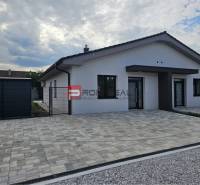 A family house on Ľadová Street in Miloslavov with a paved parking area and a garden fence.