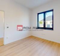 Interior of a family house with wooden flooring, a window, and an open door to the bathroom.