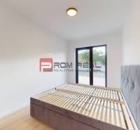 A bright room with a bed and a large window in a family house.