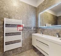 A bathroom in a family house with a sink, a mirror, and a white ladder radiator.
