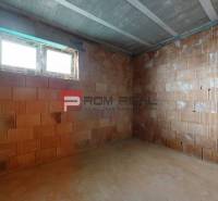 An unfinished room with raw brick walls in a family house.