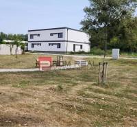 A family house in Dunajská Streda with a large grassy plot and trees on the edge.