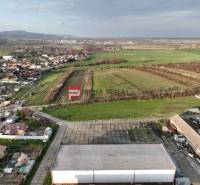 Aerial view of Vinosady from Pezinok Street, surrounded by vineyards and production facilities.