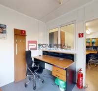 Office with a desk, chair, and fire extinguisher in the warehouse and hall areas.