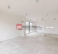 A spacious unfurnished room in a family house with white walls and a large window.