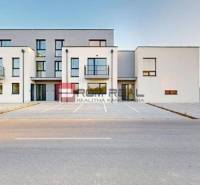 Building on Bottova Street, modern architecture, parking lot, and family house in the background.