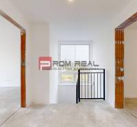 Interior of a family house with white walls, two doorways, and a window.