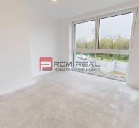 A bright, empty room in a family house with a large window and a view of the garden.