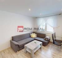 Living room in a 3-room apartment with a gray sofa, table, and chairs.