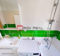 Bathroom in a 3-room apartment with white and green tiles, a shower, and a washing machine.