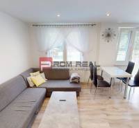 Living room in a 3-room apartment, light sofa, dining table, large windows.
