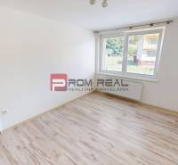 A room with laminate flooring and a large window in a 3-room apartment.