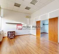 A spacious office with wooden flooring, air conditioning, and large windows.
