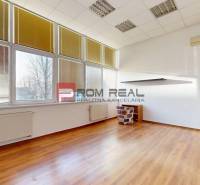 A spacious office with large windows, blinds, and lights.