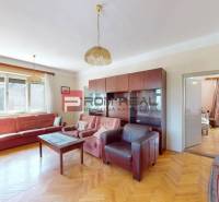 Living room in a family house with a sofa, an armchair, and a cabinet set.