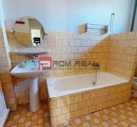 Bathroom in a family house with a shower, sink, mirror, and Italian tiles.