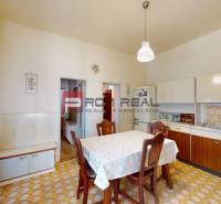 A kitchen in a family house with retro furniture and patterned flooring.