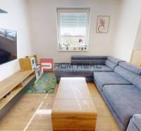 Living room in a 3-room apartment with a corner sofa, TV, and wooden furniture.