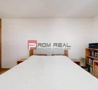 Bedroom in a 3-room apartment, wooden storage furniture elements, white walls.