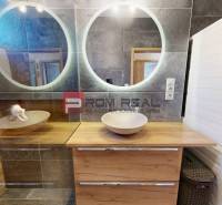 A bathroom in a 3-room apartment with a double sink and a washer with a dryer.